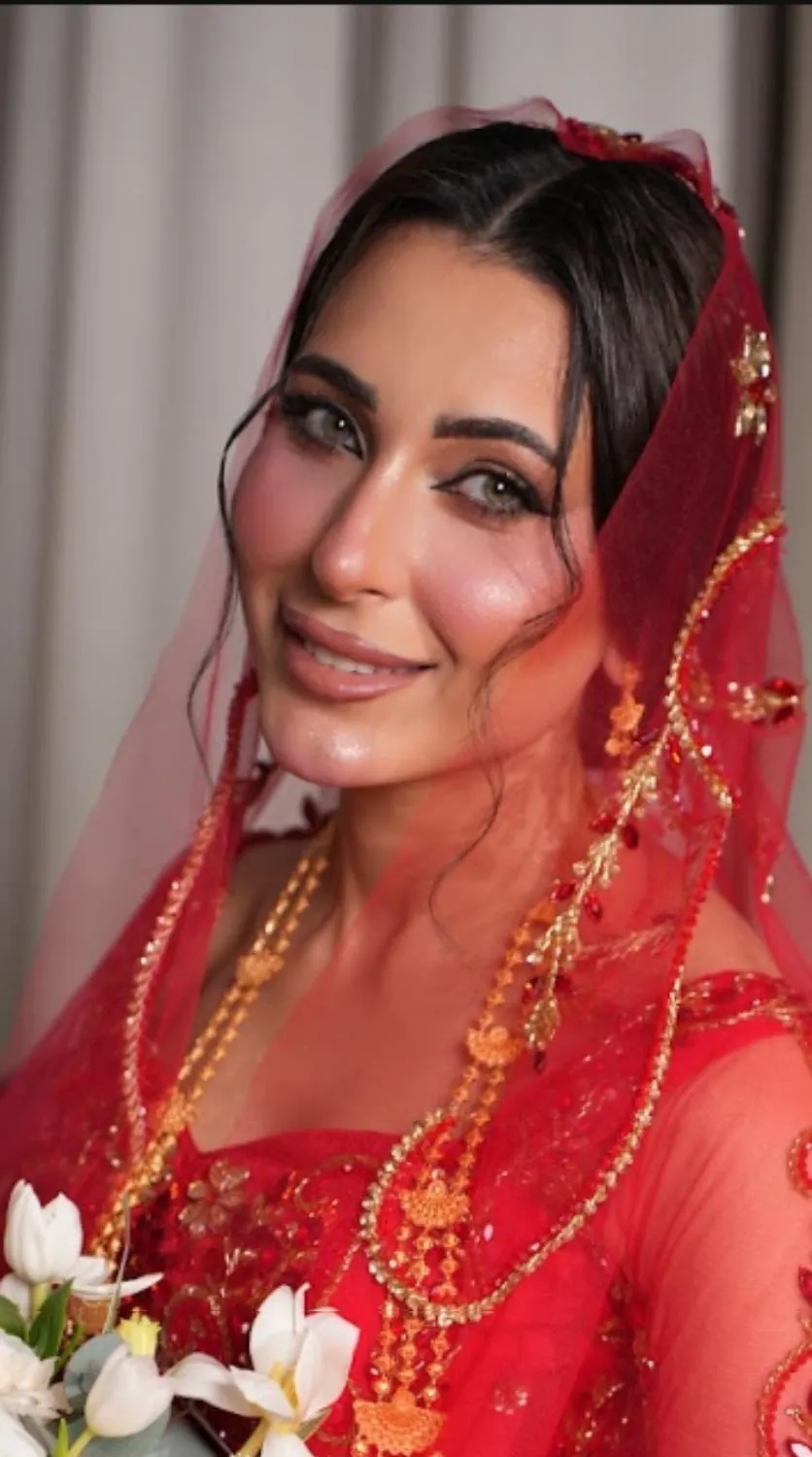 عروس بطرحة حمراء مطرزة وذهب
